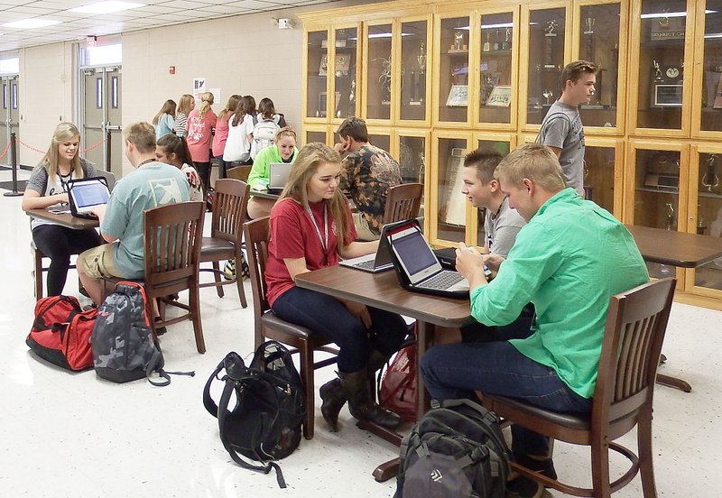 TIMES photograph by Annette Beard Students at Pea Ridge High School take advantage of the new flex-mod schedule and work on their Chrome books at tables in the lobby of the gym.