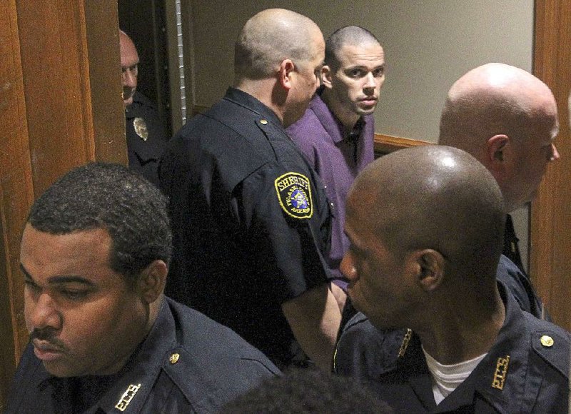 Arron Lewis (in purple shirt) is led into court Wednesday at the Pulaski County Courthouse for opening statements in his capital-murder and kidnapping trial in the 2014 slaying of real estate agent Beverly Carter.