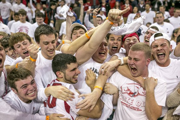 Arkansas guard Kikko Haydar, (20), celebrates in with the student section after an overtime victory in an NCAA basketball game against Kentucky on Tuesday, Jan. 14, 2014, in Fayetteville, Ark. (AP Photo/Gareth Patterson)