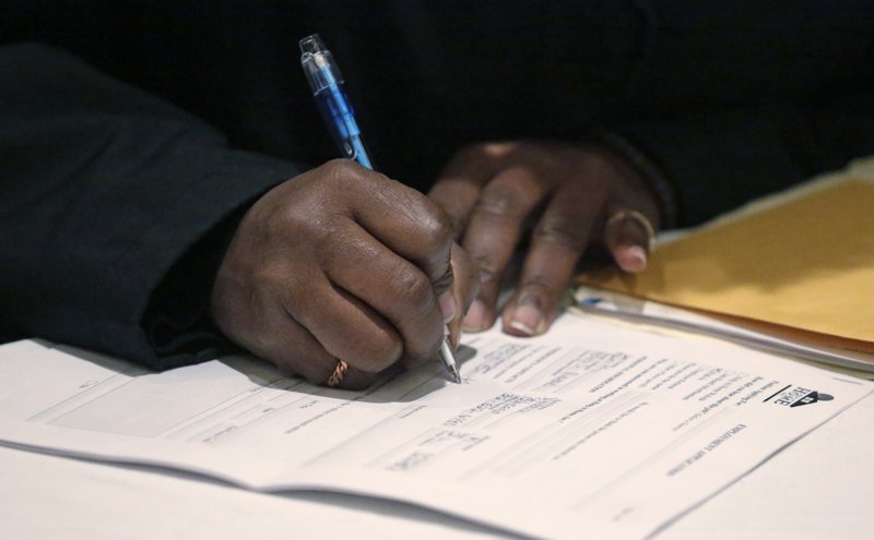 A job seeker fills out an application during a National Career Fairs job fair in Chicago. The Labor Department said Thursday, Jan. 14, 2016, applications for jobless aid rose 4,000 to a seasonally adjusted 284,000. 