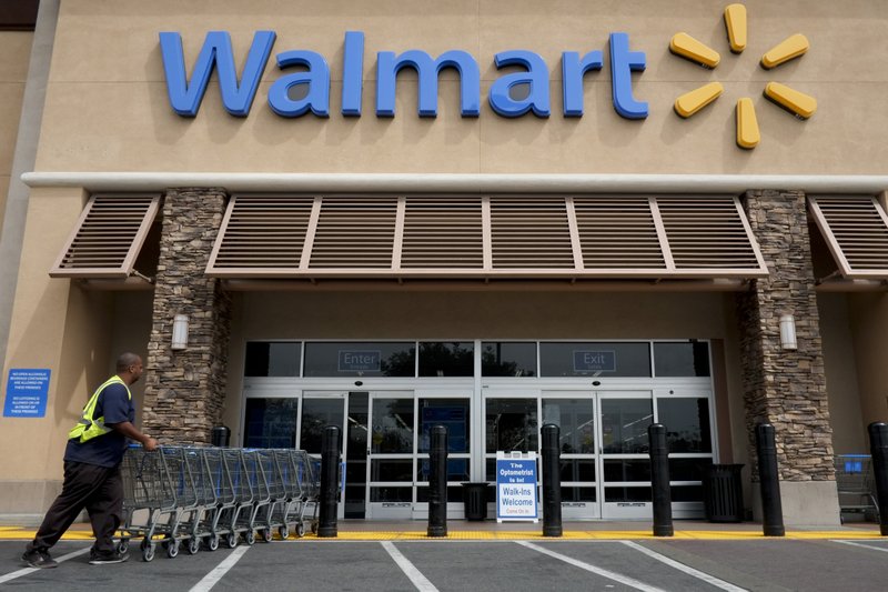 FILE - In this May 9, 2013 file photo, a worker pushes shopping carts in front of a Wal-Mart store in La Habra, Calif.  (AP Photo/Jae C. Hong, File)