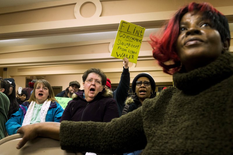 Flint residents Keri Webber, left, and Janice Barryman, center shouts out in support as more than 150 gather to protest against Gov. Rick Snyder, asking for his resignation and arrest in relation to Flint's water crisis on Thursday, Jan. 14, 2016 at the Capitol in Lansing, Mich. (Jake May/The Flint Journal-MLive.com via AP)