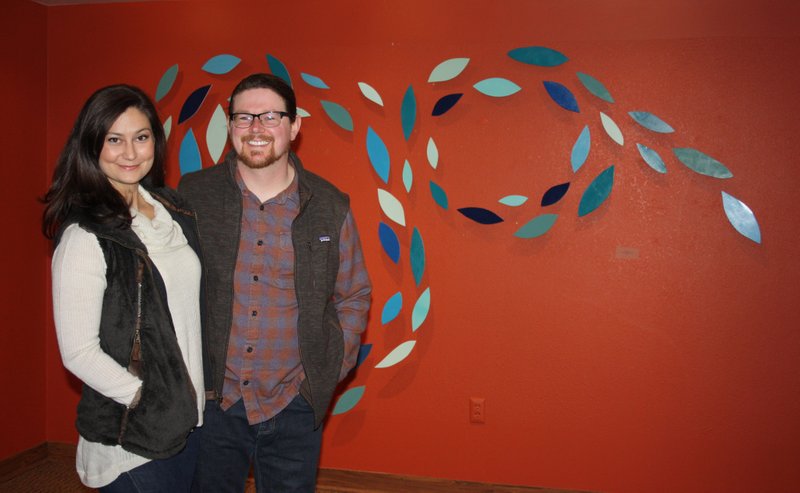 Artist Steve Adair and wife Anne Marie stand in front of “Cascade,” one of Steve’s works in his “Leaf Forms” exhibit Thursday evening at the Arts Center of the Ozarks in Springdale. 