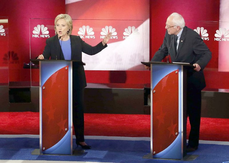 Democratic presidential candidate Hillary Clinton speaks as Bernie Sanders watches during the NBC News-YouTube Democratic presidential debate Sunday at the Gaillard Center in Charleston, S.C.