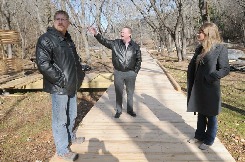 David Hook (from left), Rogers director of facilities and development, Mayor Greg Hines and Carey Anderson, assistant to the mayor, look over a boardwalk Friday near Lake Atalanta. Work is progressing on a $17.5 million renovation at the lake and park.