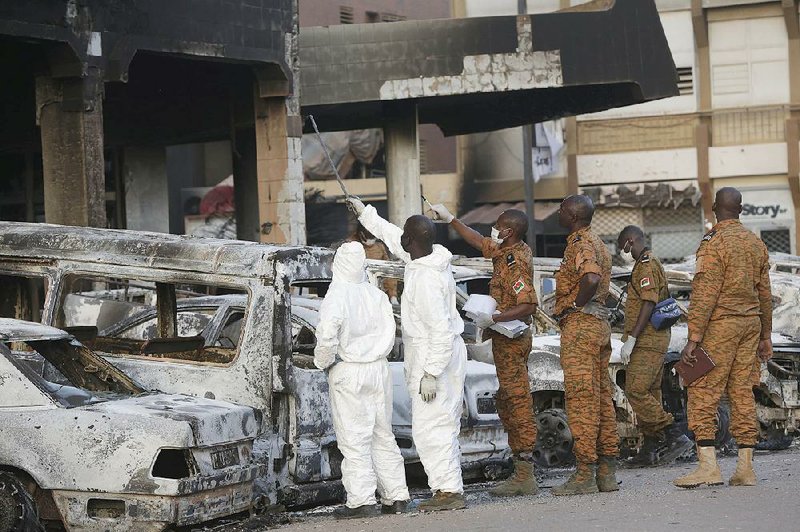 Forensic workers in protective clothing and Burkina Faso soldiers examine damage to the Splendid Hotel in Ouagadougou, Burkina Faso, on Sunday.