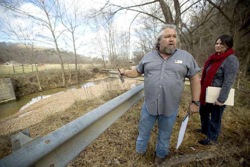 Jeff Clark and Ashley Kirby, both with the Benton County Road Department, examine on Friday the site where a bridge once crossed Limekiln Hollow Creek as part of Corinth Road in Garfield.