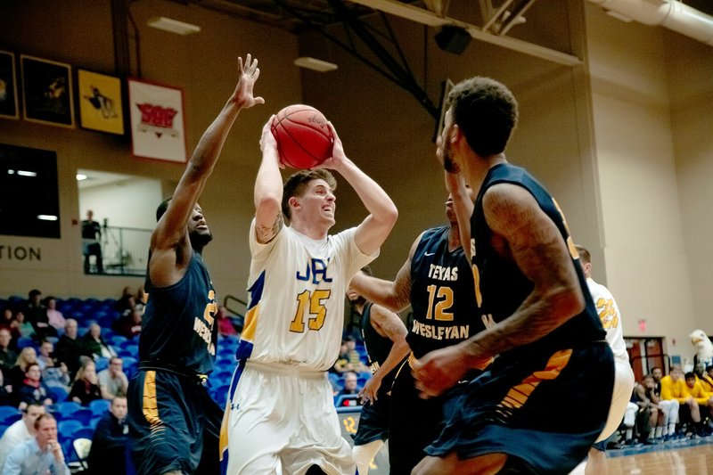 Photo courtesy of JBU Sports Information John Brown senior Luke Moyer looks to pass while surrounded by a trio of Texas Wesleyan defenders during Saturday&#8217;s game at Bill George Arena.