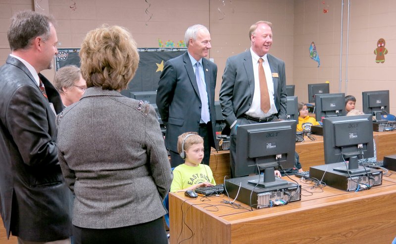 Photo by Susan Holland After speaking to students and the public at Gravette High School and to Gravette middle school and upper elementary students in the competition gym, Governor Asa Hutchinson concluded his visit to Gravette schools Friday with a tour of Glenn Duffy Elementary School. He is seen here in the computer lab at Glenn Duffy with Richard Page, superintendent of Gravette schools. Looking on, at left, are Zane Vanderpool, Glenn Duffy principal; and first lady Susan Hutchinson.