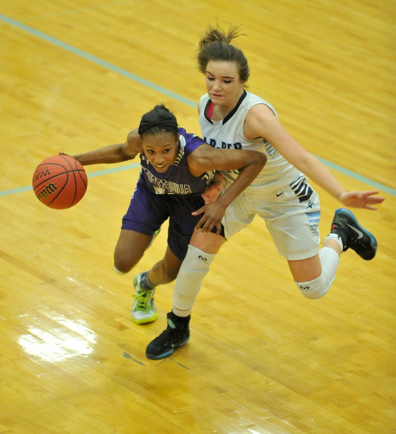 Fayetteville forward Pink Jones (11) tries to drive past Springdale Har-Ber defender Jacie Higgins (13) on Tuesday at Wildcat Arena in Springdale.