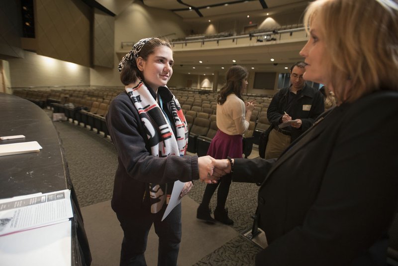 Jessica Johnson (left), Bentonville High School sophomore, shakes hands Tuesday with Teresa Hudson, Ignite Program manager for the Bentonville schools. Johnson, along with female executives from Walmart, spoke to girls at the school about the Million Women Mentors, a national initiative to support the engagement of one million science, technology, engineering, and math mentors to increase the confidence of girls and women to persist and succeed in STEM programs and careers.