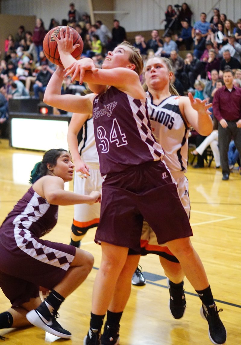 Haley Borgeteien-James, Gentry senior, is fouled by Amanda Pinter, Gravette senior, as she attempts to shoot under the basket during play between Gentry and Gravette in Gravette's competition gym on Tuesday, Jan. 19, 2016.