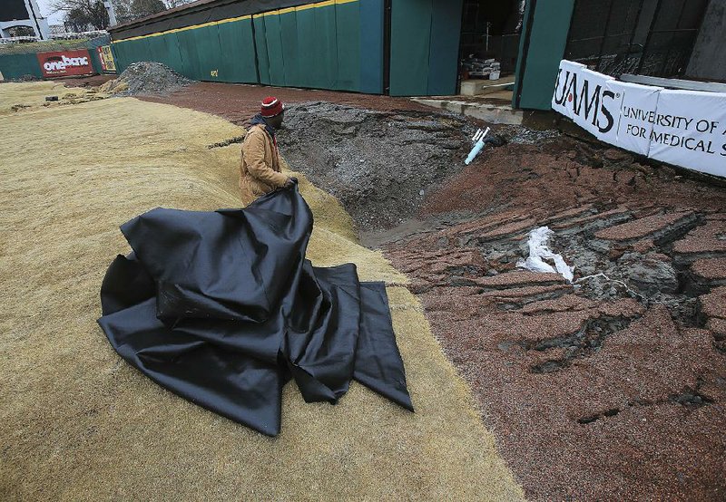 FILE — Baron Rosby of Diamond Construction Company works around a sinkhole in the outfield at Dickey-Stephens Park in North Little Rock in this 2016 file photo.