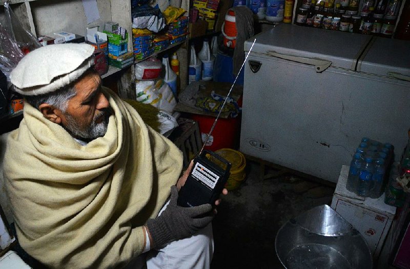 An Afghan shopkeeper listens to an Islamic State radio broadcast earlier this week in Jalalabad.