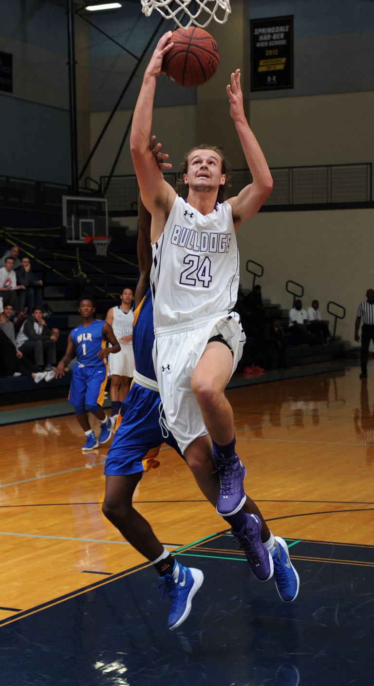 August Carlson (24) of Fayetteville scores Nov. 14 past Deion Dobbins of North Little Rock in Wildcat Arena at Springdale Har-Ber. Visit nwadg.com/photos to see more photographs from the game.