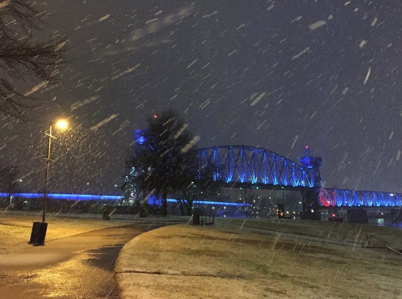 Snow falls Thursday, Jan. 21, 2016, along the Arkansas River in Little Rock's River Market district as part of a winter storm that is predicted to bring several of snow to portions of central Arkansas.
