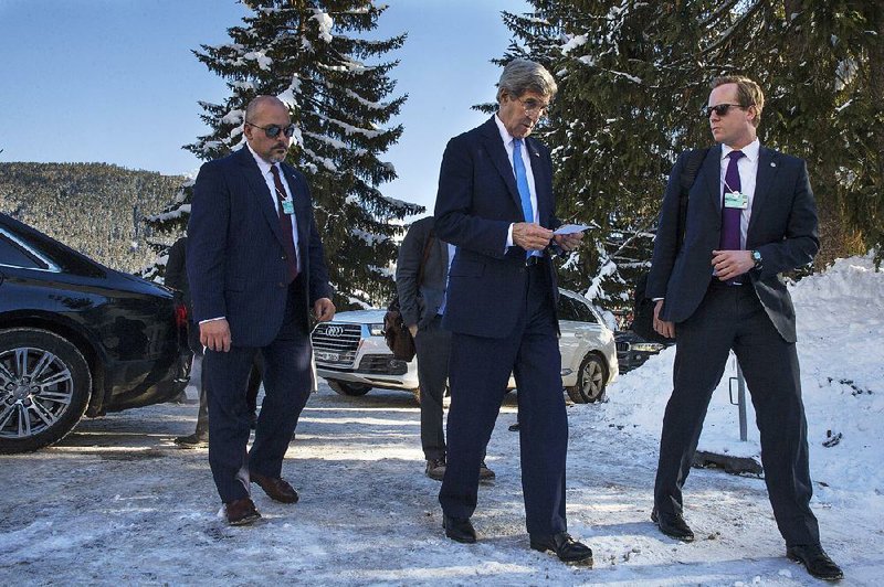 U.S. Secretary of State John Kerry (center) arrives Friday at the Derby Hotel for a meeting during the World Economic Forum in Davos, Switzerland, where falling oil prices were a concern for crude-producing nations. 