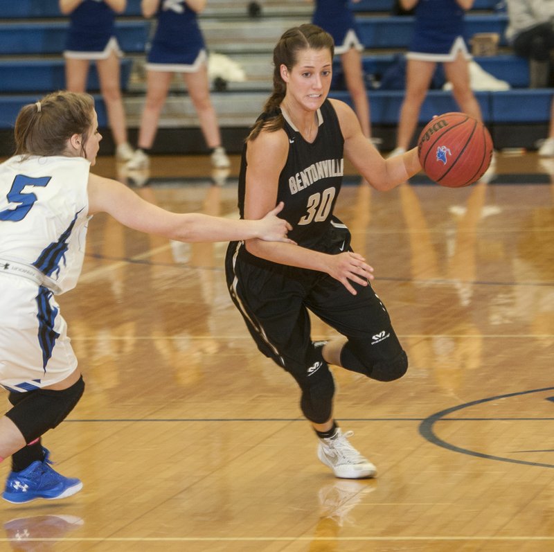 Madison Brittain, Bentonville senior guard, slips Friday past the grasp of Emma Wisdom, Rogers High junior guard, in the second half at King Arena in Rogers.