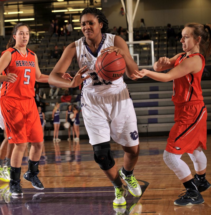  Jasmine Franklin (center) of Fayetteville drives Friday past Shelby Thompson (5) and Sydney Kinnamon (right) of Rogers Heritage at Bulldog Gymnasium in Fayetteville. Visit nwadg.com/photos to see more photographs from the game.