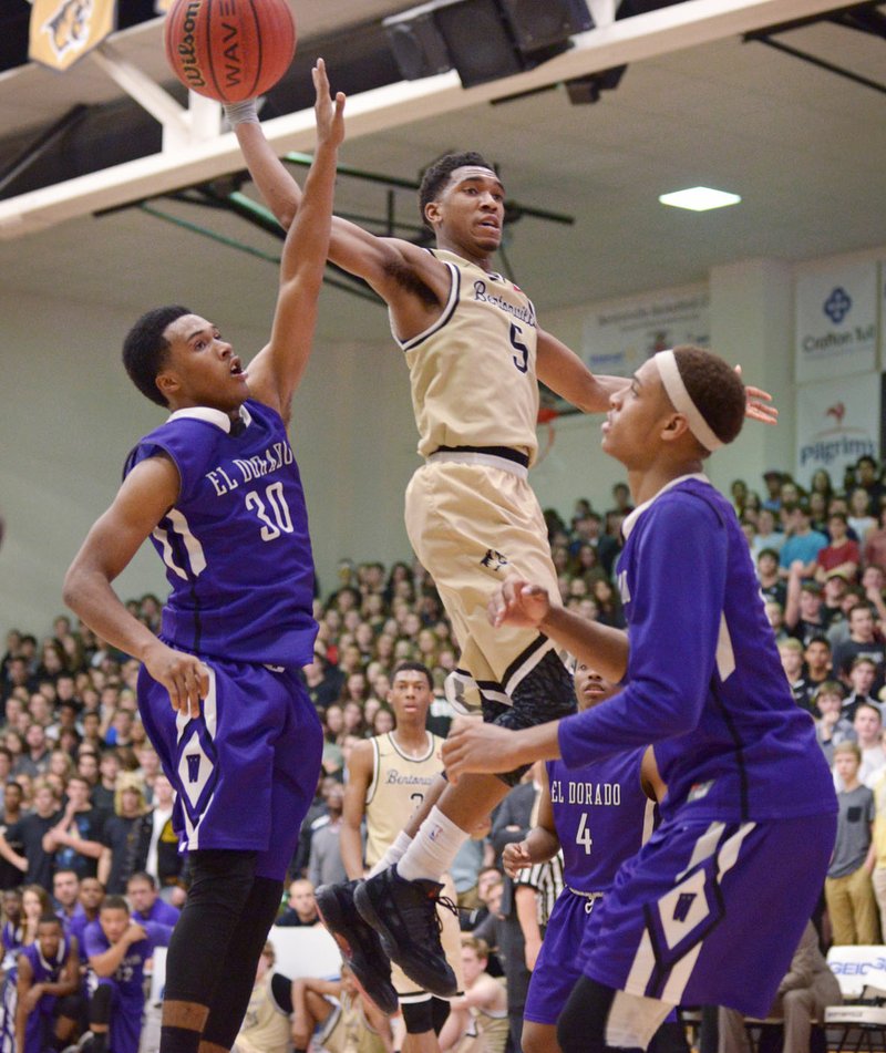 Malik Monk of Bentoville passes the ball Friday as Josh Ford (30) of El Dorado guards in Bentonville’s Tiger Arena.