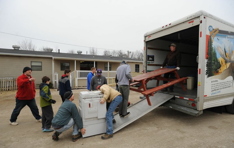 Volunteers work together Saturday to unload items at Seven Hills Homeless Center’s new day center at 1832 S. School Ave. in Fayetteville.