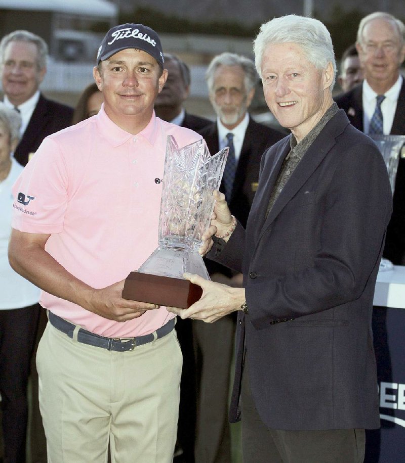 Jason Dufner, left, poses with former president Bill Clinton, right, each holding the trophy, after Dufner defeated David Lingmerth, of Sweden, (not pictured) in the second playoff round of the CareerBuilder Challenge golf tournament on the TPC Stadium course at PGA West in La Quinta, Calif., Sunday, Jan. 24, 2016. 