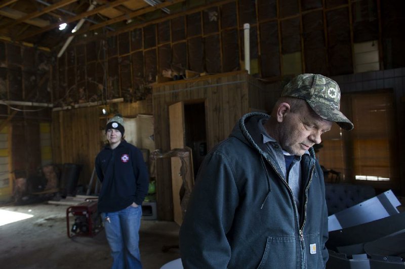 B.J. Bradford, assistant chief of the Quail Creek Volunteer Fire Department, steps outside the firestation Saturday in Pulaski County as Capt. Sarah Stefans looks on. The department runs on a $30,000 annual budget.