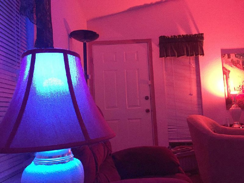 The Ilumi A19 LED Smartbulb (left) glows blue, while the BR30 LED Flood Smartbulb (right) glows red, both controlled by a free smartphone app, which can adjust the bulbs to a variety of colors.