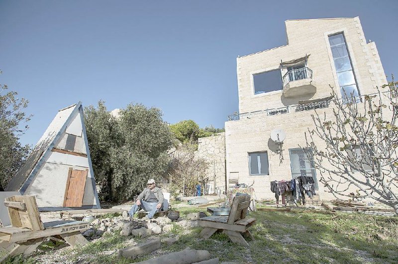 Moshe Gordon sits outside his guesthouse in the Nofei Prat settlement on the West Bank. The house is advertised on the Airbnb international home-sharing site.