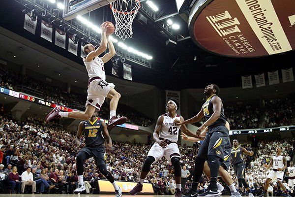 Texas A&M's Alex Caruso (21) dunks the ball as teammate Tavario Miller (42), Missouri's Namon Wright (12) and Kevin Puryear (24) react during the first half of an NCAA college basketball game, Saturday, Jan. 23, 2016, in College Station, Texas. Texas A&M won 66-53. (AP Photo/Sam Craft)
