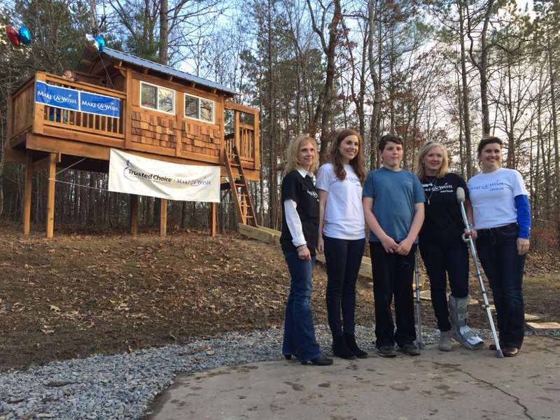 Make-A-Wish Foundation volunteers surround Caleb Waddle, 11, of Alexander on Monday, Jan. 25, 2016, after Waddle walked up the steps into his newly built treehouse for the first time.