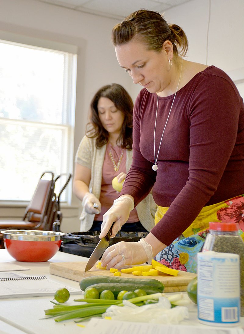 Photo by Janelle Jessen Cooking Matters instructor Elizabeth Smith chopped vegetables during a class last March. Bridges to Wellness of Siloam Springs will be expanding the program to Decatur beginning in March.