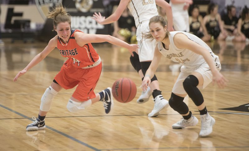 Rogers Heritage's Amber Turner and Bentonville's Krista Clark scramble for a loose ball Tuesday in Bentonville.