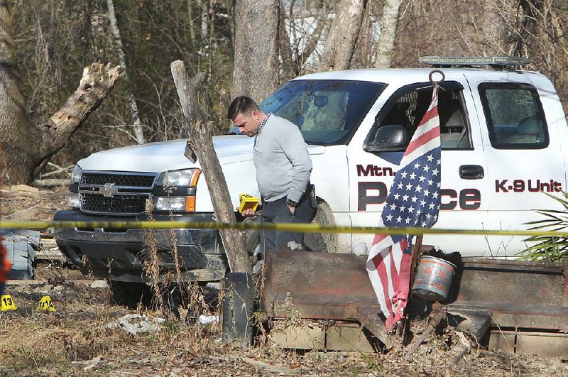 Garland County sheriff’s investigator A.J. Tart works the scene where a trespassing suspect was shot and killed and Mountain Pine Police Chief Chad King was shot and injured. King was in stable condition Wednesday afternoon at a hospital in Hot Springs. 