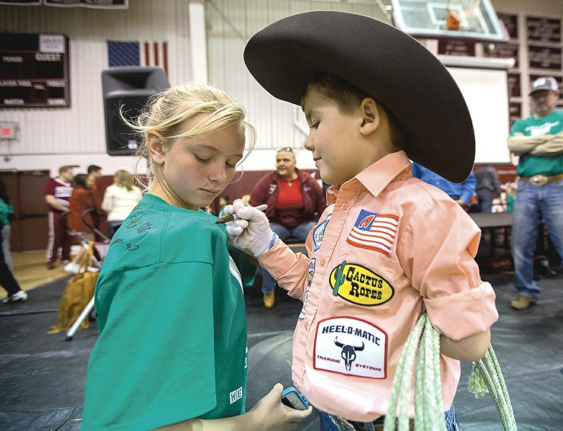 Colton Workman autographs a T-shirt for Lincoln Middle School seventh-grader Chloe Dawson during a recent assembly to combat bullying.