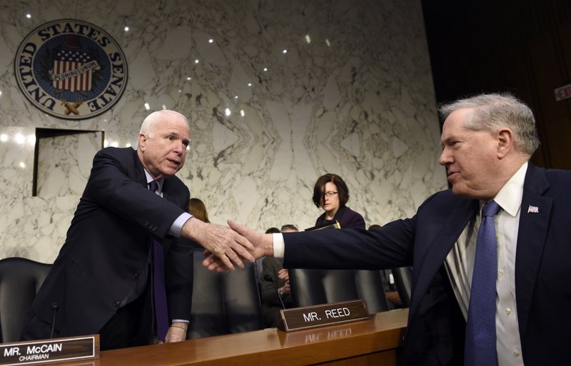 Senate Armed Services Committee Chairman Sen. John McCain, R-Ariz., left, shakes hands with Defense Undersecretary Frank Kendall, the military's chief weapons buyer, right, before the start of a hearing on Capitol Hill in Washington, Wednesday, Jan. 27, 2016, on Russian-made rockets for military satellites. 