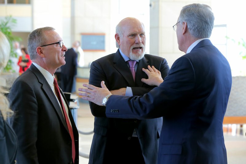 University of Arkansas Athletic Director Jeff Long (left) and UAMS Chancellor Dan Rahn (right) talk with former NFL quarterback Terry Bradshaw before a UA System board of trustees meeting Wednesday in Little Rock. 