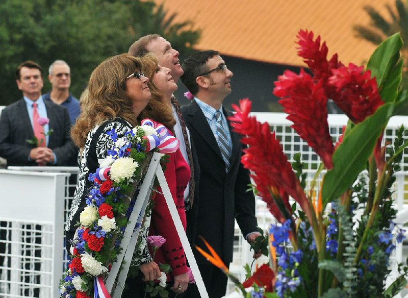 Sheryl Chaffee, (from left) daughter of Apollo 1 astronaut Roger Chaffee; Kathie Scobee Fulgham and Air Force Maj. Gen. Richard Scobee, children of Challenger commander Dick Scobee; and Scott McAuliffe, son of Challenger schoolteacher Christa McAuliffe, look for their loved ones’ names on the Astronaut Memorial during Thursday’s gathering at the Kennedy Space Center in Florida.