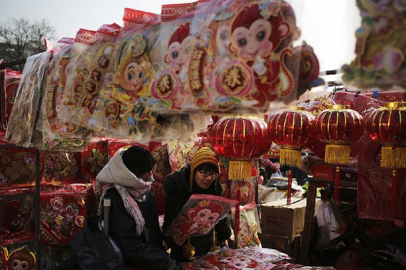 A woman selects Lunar New Year decorations at a market in Beijing on Thursday. The Lunar New Year is Feb. 8. 