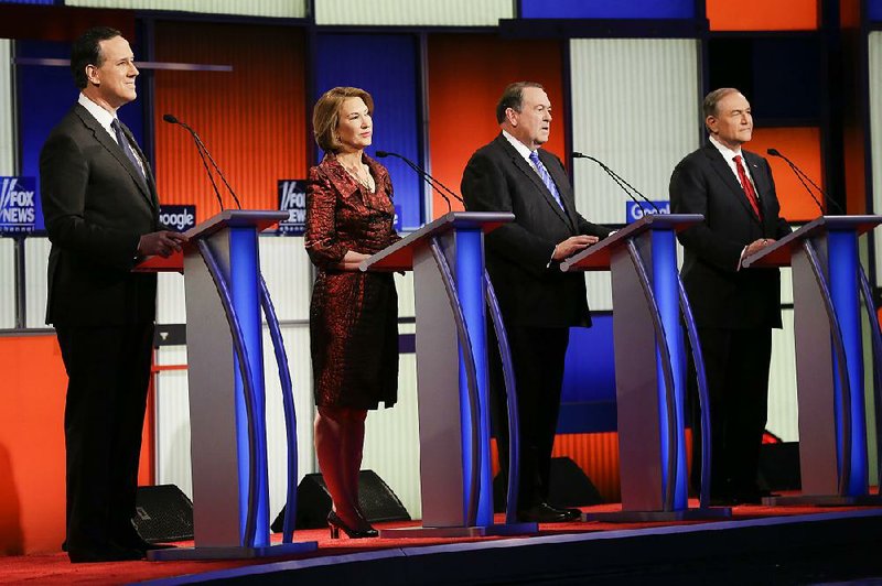 Former Pennsylvania Sen. Rick Santorum, (from left) business executive Carly Fiorina, former Arkansas Gov. Mike Huckabee and former Virginia Gov. Jim Gilmore take to the stage for Thursday’s Republican debate in Des Moines, Iowa.