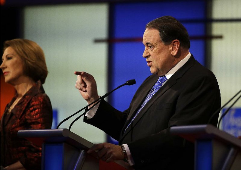 Former Arkansas Gov. Mike Huckabee makes a point during one of Thursday night’s debates in Des Moines, Iowa. Huckabee won the Iowa caucuses eight years ago but trails in the polls this year.