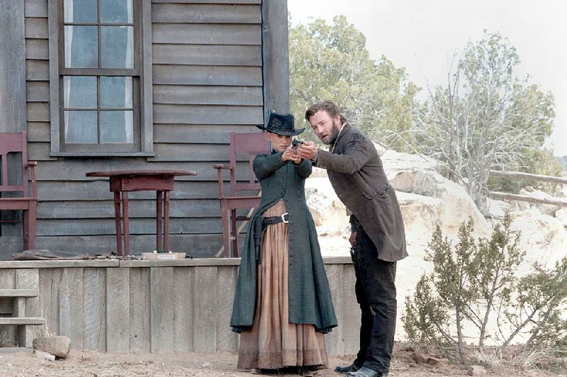 Jane Hammond (Natalie Portman) receives some firearms instruction from her neighbor (and former fiance) Dan Frost (Joel Edgerton) in the slow-burning Western Jane Got a Gun.