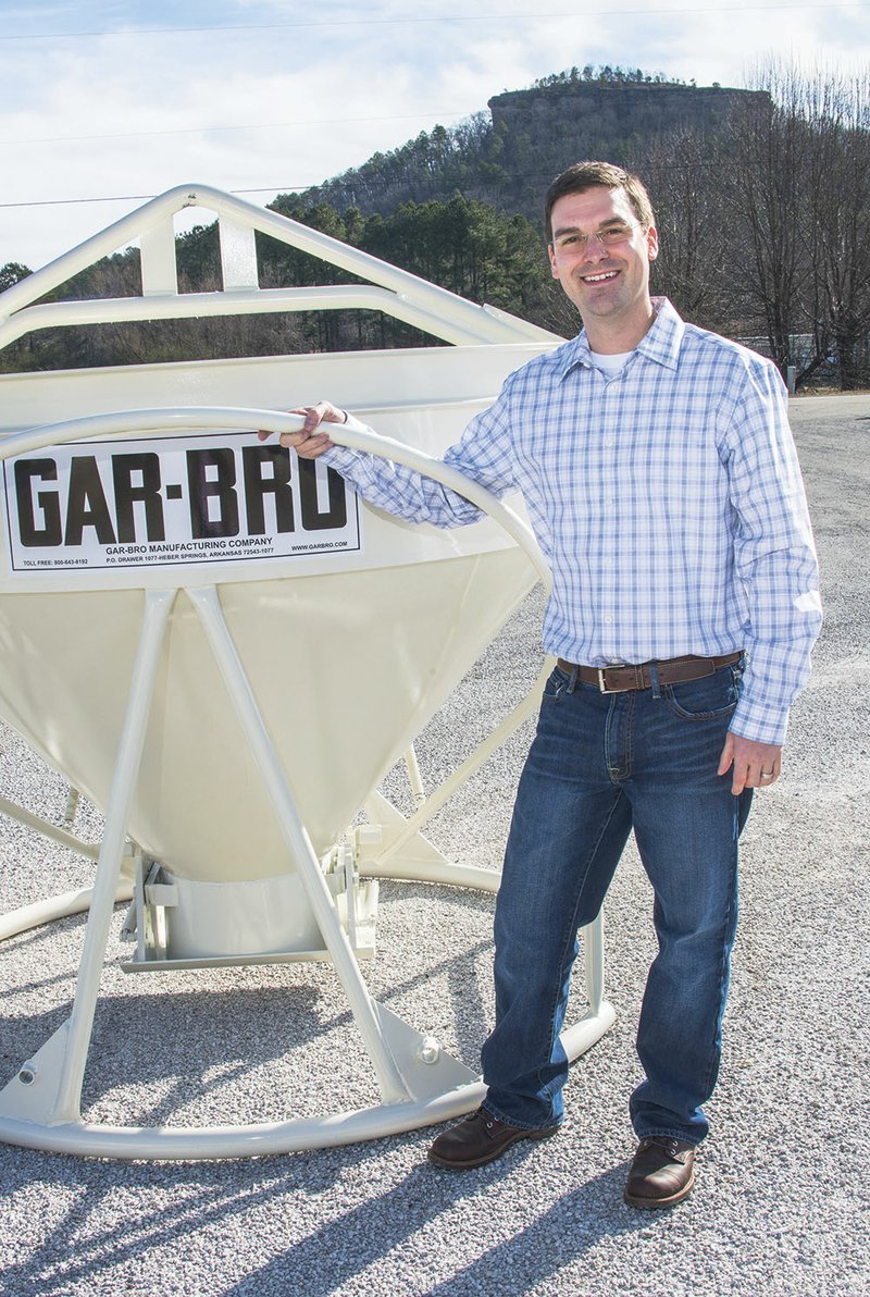 Jim Adams is shown with one of the concrete buckets that his company, GAR-BRO Manufacturing, makes. He stands under the shadow of Sugar Loaf Mountain in Heber Springs, where he has taken over as president of the chamber board for the Heber Springs area.