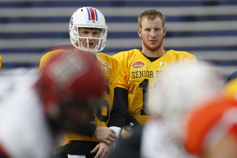 Louisiana Tech quarterback Jeff Driskel, left, and North Dakota State quarterback Carson Wentz, right, wait to run through drills during NCAA college football practice for the Senior Bowl, Thursday, Jan. 28, 2016, at LaddPeebles Stadium, in Mobile, Ala. 