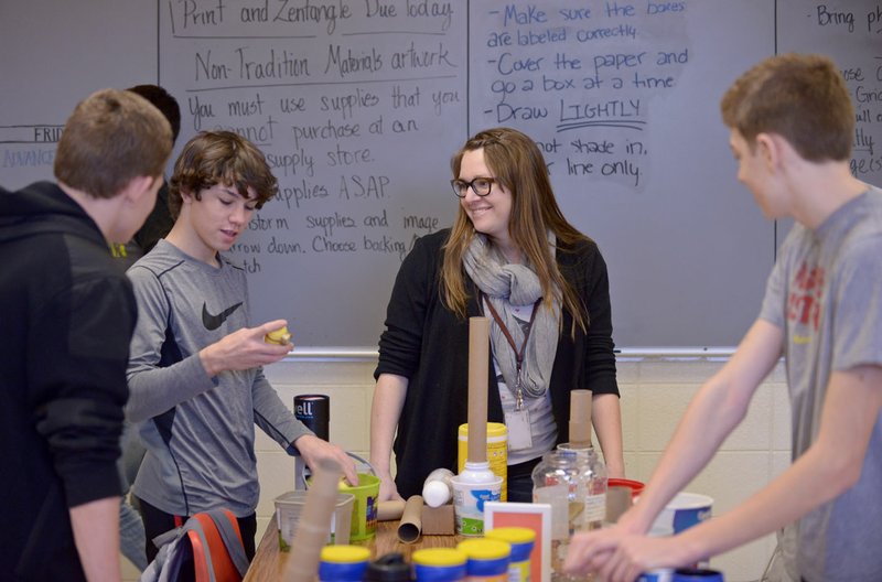 Jenn Tatum helps Zach Hardcastle (from left), Colin Verdoorn and Derek McGuire get started Friday on making an art project from nontraditional material in Tatum’s eighth-grade advanced art class at Washington Junior High School in Bentonville.