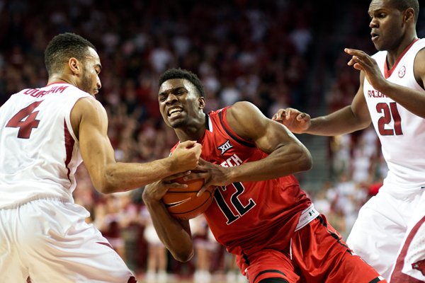 Texas Tech's Keenan Evans (12) struggles to maintain control of the ball against Arkansas' Jabril Durham (4), left, and Manuale Watkins (21), right, in the second half of an NCAA college basketball game in Fayetteville, Ark., Saturday, Jan. 30, 2016. Arkansas won 75-68. (AP Photo/Sarah Bentham)