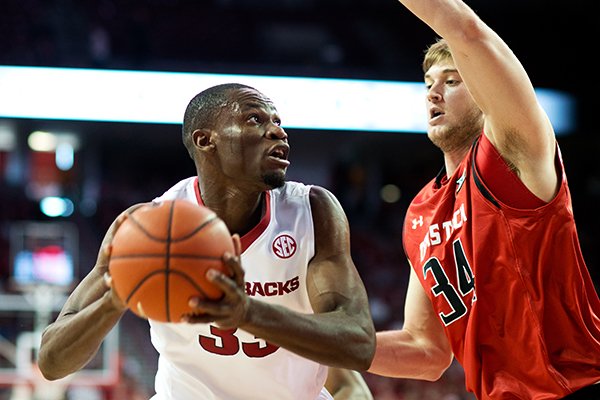 Arkansas' Moses Kingsley (33) looks to the basket as Texas Tech's Matthew Temple (34) defends in the first half of an NCAA college basketball game in Fayetteville, Ark., Saturday, Jan. 30, 2016. (AP Photo/Sarah Bentham)
