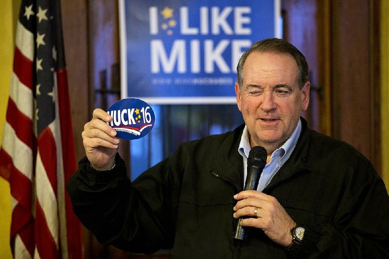 Former Arkansas Gov. Mike Huckabee jokes with voters in Cherokee, Iowa, earlier this month. He is banking on social conservatives’ support in Monday’s Iowa caucus. 