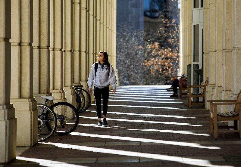 Sydney Carson, a freshman from Shawnee, Kan., walks along the east side of Mullins Library at the University of Arkansas at Fayetteville, the oldest campus in the University of Arkansas System. The UA System, the largest in the state, hopes to add more campuses to its network of higher-education institutions.