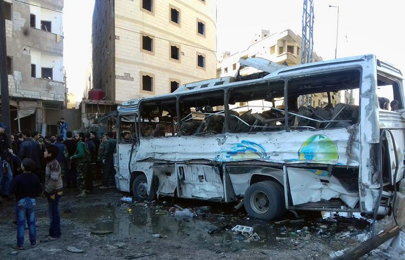 Syrians gather where three bombs exploded in Sayyda Zeinab, a predominantly Shiite Muslim suburb of Damascus, on Sunday in this photo released by the Syrian official news agency SANA.